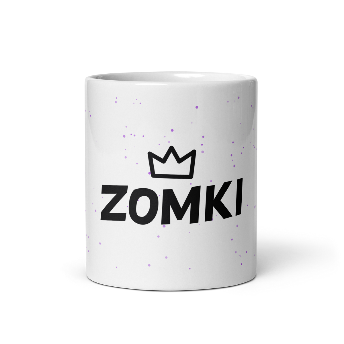 Taza ZOMKI Crew blanca: vista frontal del logotipo negro y corona sobre confeti lila