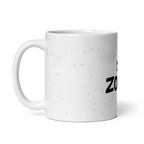 Taza ZOMKI Crew blanca con confeti lila, vista lateral con el asa a la izquierda