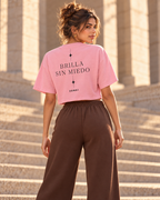 Idea de combinación: vista trasera con modelo, camiseta corta ZOMKI Brilla sin miedo rosa y pantalón Soft Rebel chocolate. Cada prenda se vende por separado. Imagen generada con IA.
