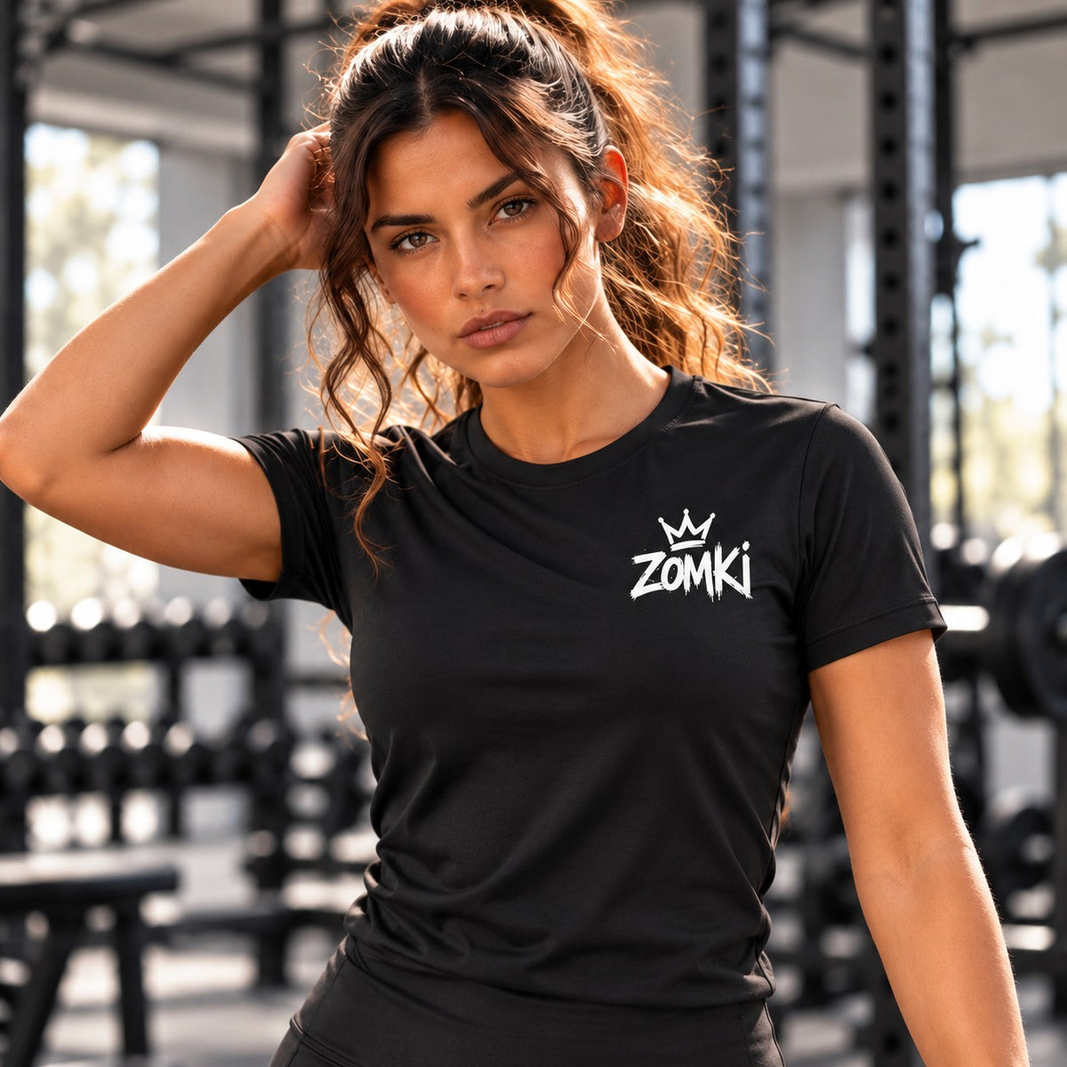 Modelo con camiseta mujer ZOMKI Gym Arriba los locos. Se vende únicamente la camiseta. Visualización generada con IA; consultar maquetas oficiales en galería.