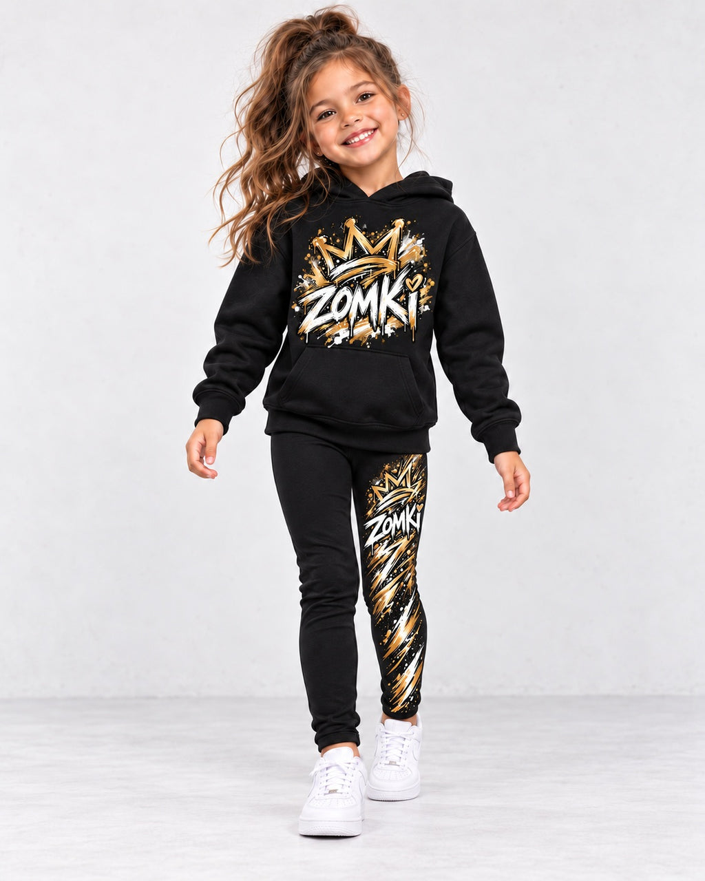 Conjunto infantil negro ZOMKI Graffiti Dorado de sudadera con capucha y leggings, con el mismo modelo sintético IA niña en una nueva pose