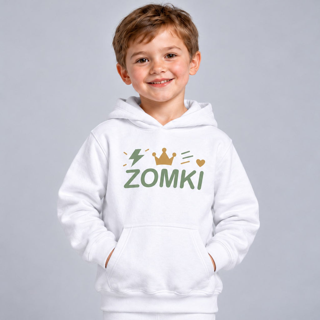 Modelo infantil sintético con sudadera blanca ZOMKI Corona Verde salvia: logotipo con corona, corazón, rayo y trazos de energía. Se vende solo la sudadera. Imagen generada con IA.