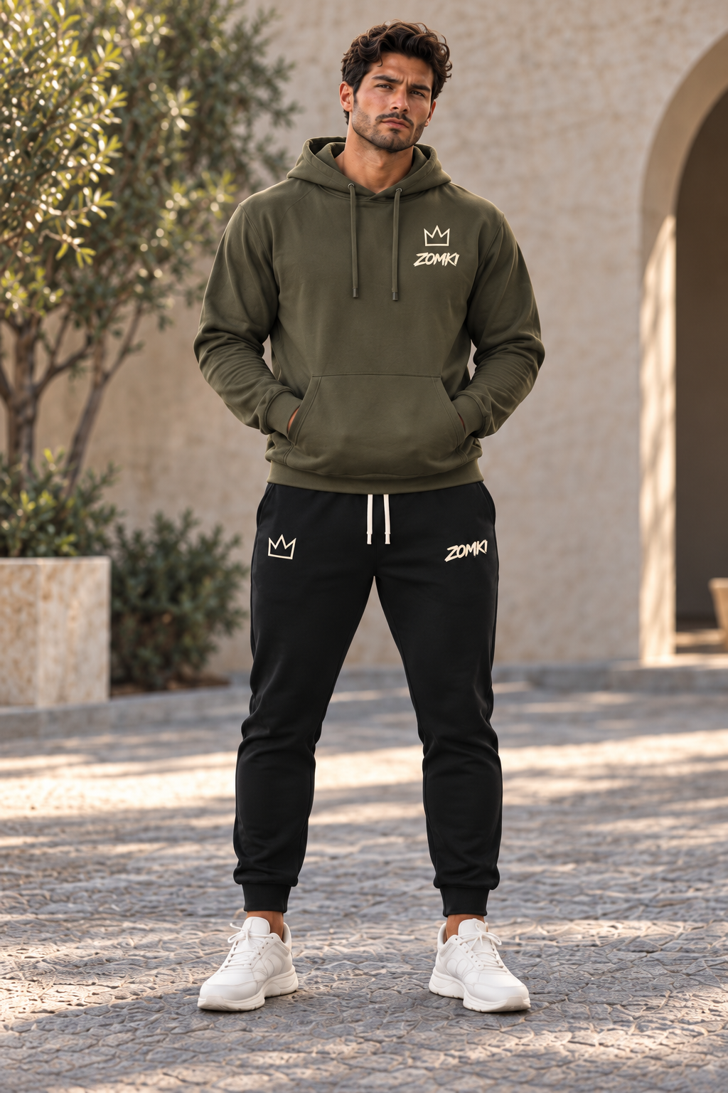 Modelo con sudadera ZOMKI El Presente oliva y jogger negro, vista frontal. Cada prenda se vende por separado. Imagen generada con IA.