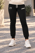 Pantalón jogger negro ZOMKI El Presente para mujer, puesto en la modelo y mostrado de cintura a pies. Se vende únicamente el pantalón. Imagen generada con IA.