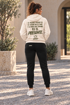Modelo de espaldas con sudadera ZOMKI El Presente marfil y jogger negro; firma trasera del pantalón en el lado izquierdo. Cada prenda se vende por separado. Imagen generada con IA.
