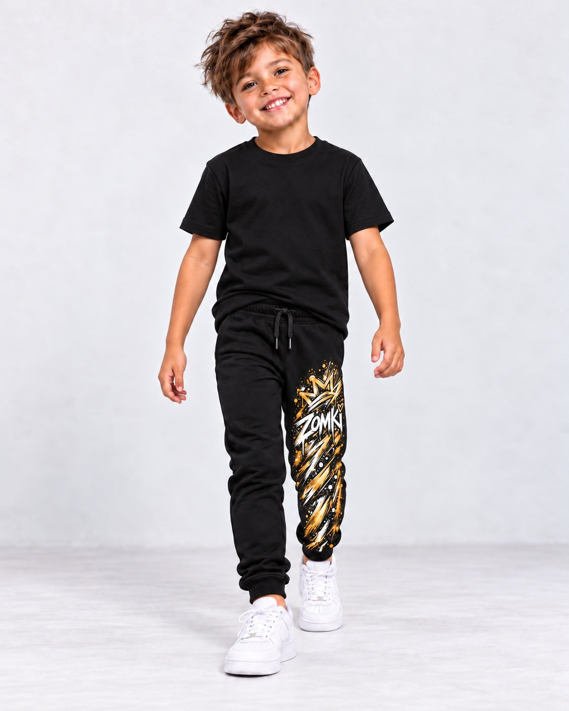Modelo sintético generado con IA: jogger negro ZOMKI Graffiti Dorado, estampado vertical en la pierna izquierda; camiseta de estilismo no incluida