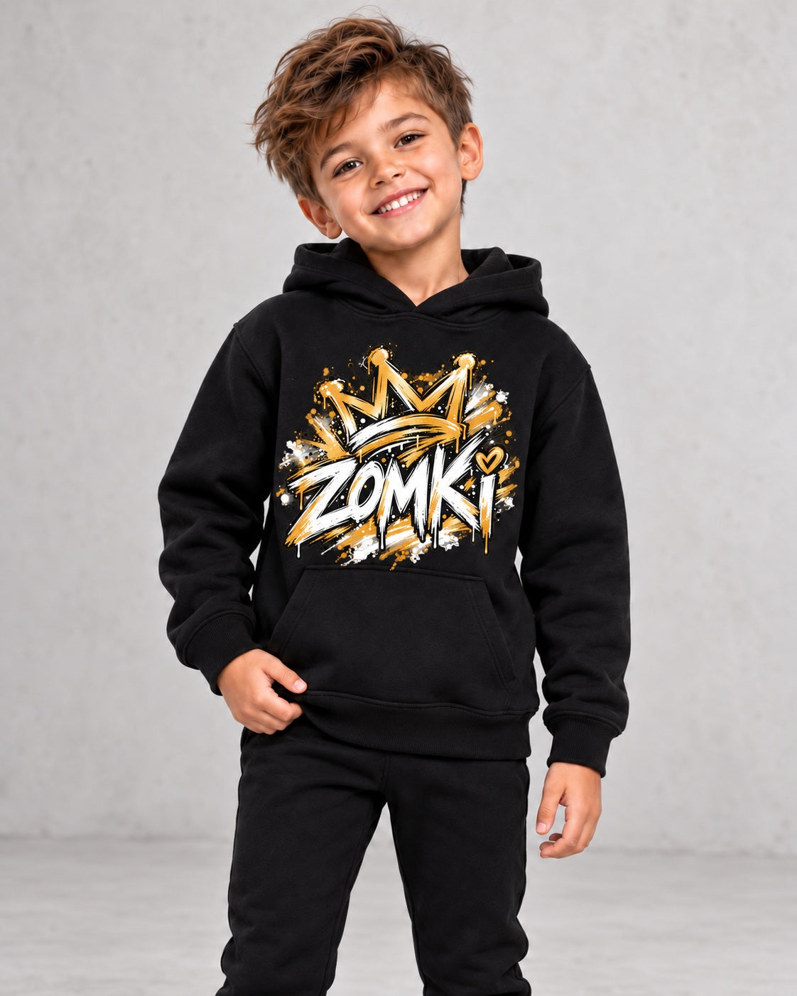 Modelo sintético generado con IA: sudadera infantil ZOMKI Graffiti Dorado negra; vista con niño, prenda suelta