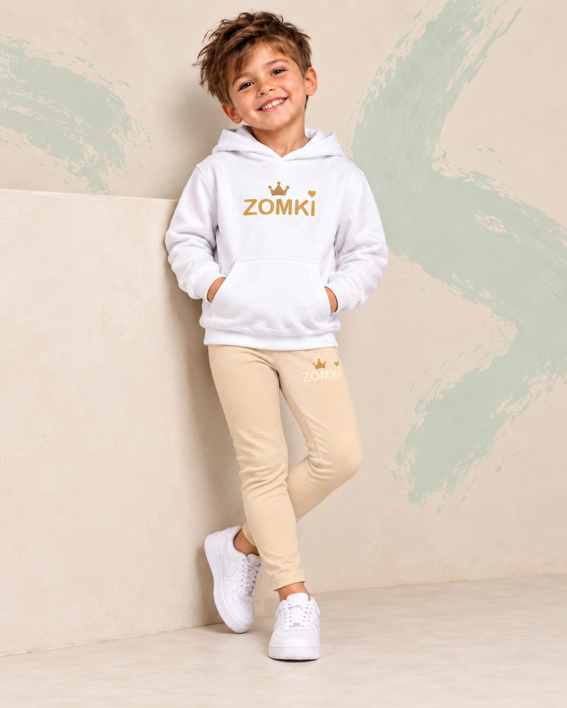 Conjunto infantil ZOMKI Corona · Beige y mostaza · Sudadera + leggings, en modelo masculino oficial ZOMKI. Se vende el conjunto de dos prendas. Imagen creada con IA; maquetas de producto en galería.