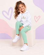 Conjunto infantil ZOMKI Corona · Menta y melocotón · Sudadera + leggings, en modelo femenina oficial ZOMKI. Se vende el conjunto de dos prendas. Imagen creada con IA; maquetas de producto en galería.