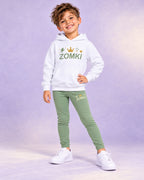 Conjunto infantil ZOMKI Corona · Verde salvia · Sudadera + leggings, en modelo masculino oficial ZOMKI. Se vende el conjunto de dos prendas. Imagen creada con IA; maquetas de producto en galería.