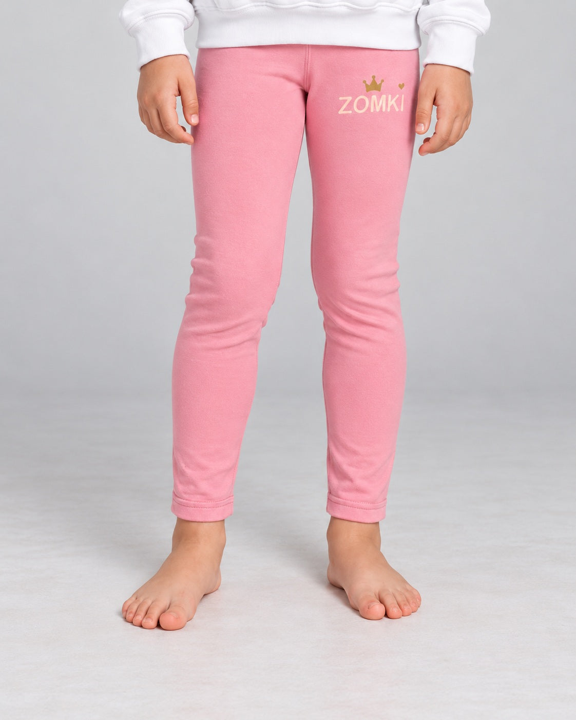 Modelo con Leggings infantiles ZOMKI Corona · Rosa. Se venden únicamente los leggings. Encuadre individual de la prenda. Imagen generada con IA.