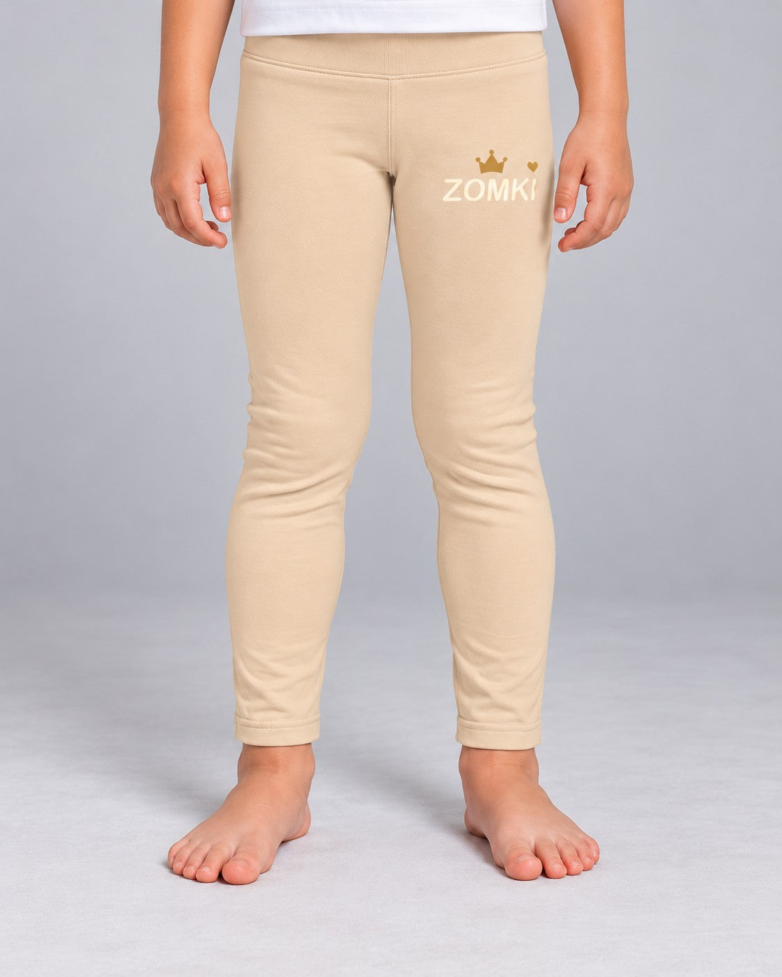Modelo con Leggings infantiles ZOMKI Corona · Beige. Se venden únicamente los leggings. Encuadre individual de la prenda. Imagen generada con IA.