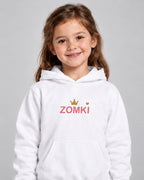 Modelo con Sudadera infantil ZOMKI Corona · Blanca y rosa. Se vende únicamente la sudadera. Encuadre individual. Imagen generada con IA.